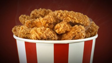 Kağıt kovada kızarmış tavuk parçaları, renkli arka planda izole edilmiş. Hurda Gıda Konsepti.