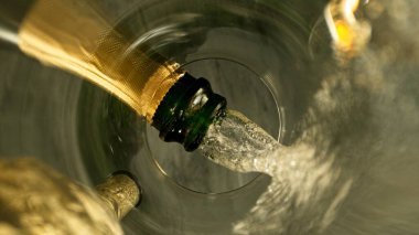 Şampanya Şarabı kadehe dökülüyor. Bardağın Altından Eşsiz Bakış Görünümü.