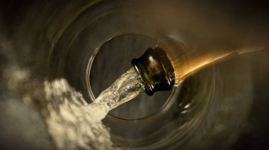 Şampanya Şarabı kadehe dökülüyor. Bardağın Altından Eşsiz Bakış Görünümü.