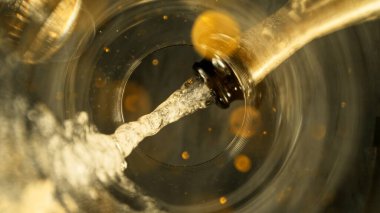 Şampanya Şarabı kadehe dökülüyor. Bardağın Altından Eşsiz Bakış Görünümü.