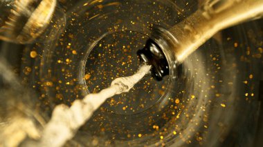 Şampanya Şarabı kadehe dökülüyor. Bardağın Altından Eşsiz Bakış Görünümü.