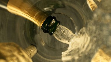 Şampanya Şarabı kadehe dökülüyor. Bardağın Altından Eşsiz Bakış Görünümü.