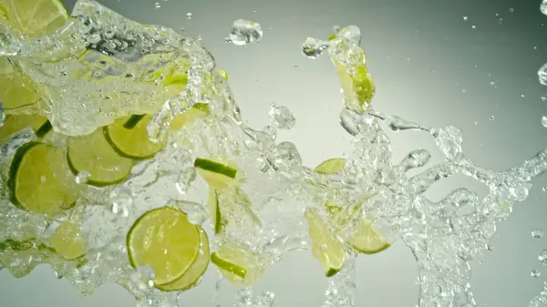 Jäädyttäminen Motion Flying Slices Limes Splashing Water Eristetty Harmaalla Pohjalla — kuvapankkivalokuva