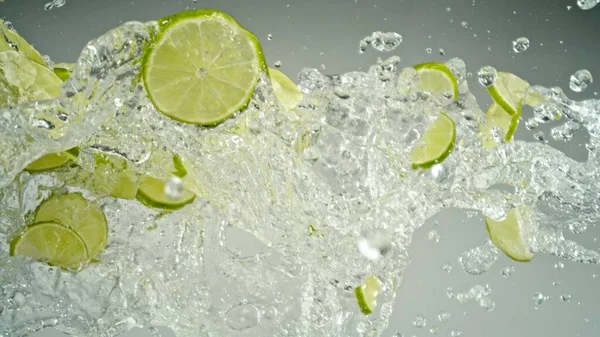 Freeze Motion Flying Slices Limes Splashing Water Inglês Isolado Fundo — Fotografia de Stock