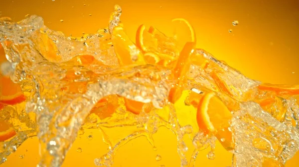 Freeze Motion Flying Slices Oranges Splashing Water Isolated Colored Background — Stock Photo, Image
