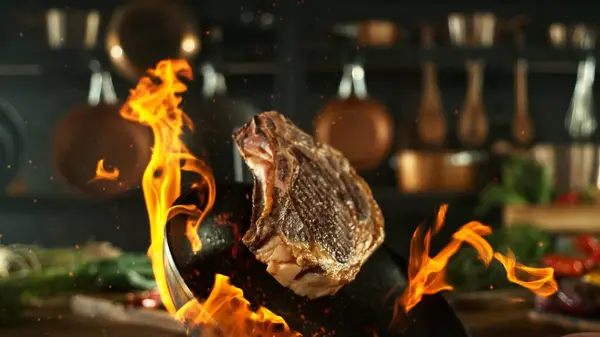 공중에서 팬에서 맛있는 쇠고기 스테이크 배경에 도구가있는 식품의 스톡 이미지