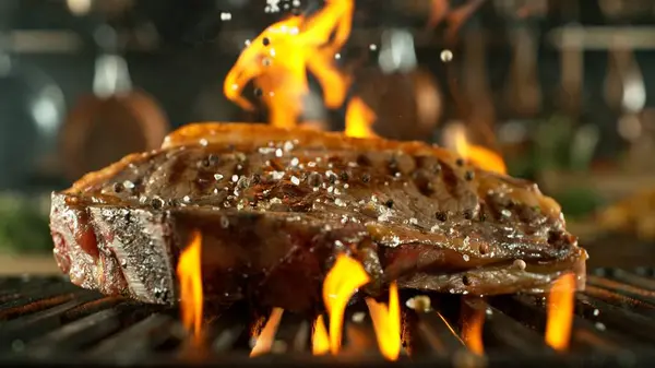 그리드에 맛있는 쇠고기 스테이크 배경에 도구가있는 준비의 스톡 사진
