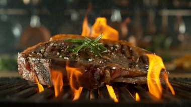 Izgarada Ateşli Biftek Bifteği. Arka planda Tava ve Tencereli Mutfak.