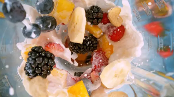 믹서기에 우유와 과일의 조각의 스무디 음료의 스톡 사진