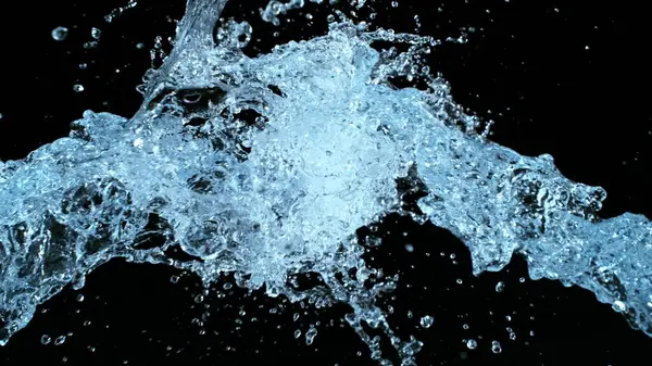 ブラックバックグラウンドで飛行する水スプラッシュ 現実的な水スプラッシュの凍結動き ストック画像