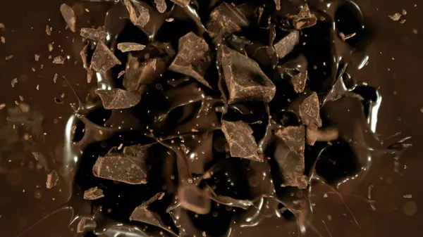 Gefrierbewegung Einer Fliegenden Gruppe Roher Schokoladenstücke Die Geschmolzene Schokolade Fallen Stockfoto