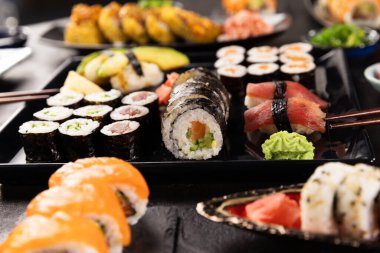 Kara Taş Masa 'da servis edilen çeşitli suşi parçalarının detaylı görüntüsü. Japon Mutfağı Suşi Rolls Konsepti.