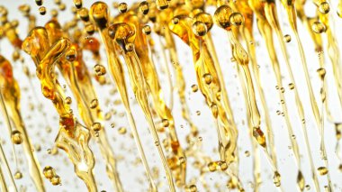 Beyaz Arkaplanda Su Sıçratan Yağın Dondurucu Çekimi. Soyut Altın Sıvı Damlaları.