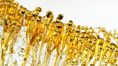 Beyaz Arkaplanda Su Sıçratan Yağın Dondurucu Çekimi. Soyut Altın Sıvı Damlaları.