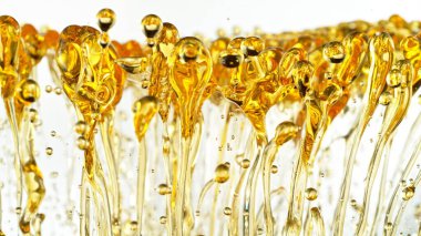 Beyaz Arkaplanda Su Sıçratan Yağın Dondurucu Çekimi. Soyut Altın Sıvı Damlaları.