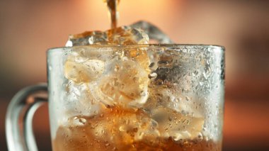Kahverengi sıvıyı kupaya döküyorum. Taze Buzlu Kahve, Kola veya Çay İçeceği Hazırlama, Görüntü Endüstriyel Arkaplanda.