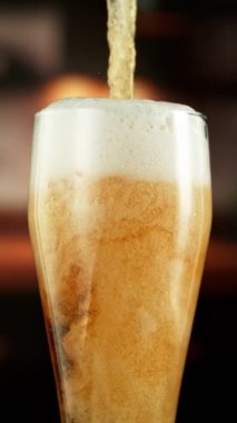 Pint in Detail 'e Süper Yavaş Bira Dökümü. High Speed Cinema Camera 'da çekildi, 1000 fps. Arka planda Görüntü Endüstriyel İçişleri. Kamera hareket halinde. Dikey Görünüm Oranı.