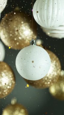 Renkli Parlak Toplar ve Parıldayan Parıltılar Düşen Noel Madalyası. Güzel Tatil Yavaş Sinema Görüntüleri. High Speed Cinema Camera 'da çekildi, 1000 fps. Dikey Görünüm Oranı.