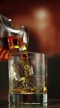 Viskiyi bardağa doldurmanın süper yavaş hareketi. High Speed Cinema Camera 'da çekildi, 1000 fps. Kamera Hareket Kontrol 'e yerleştirildi. Arkaplanda Bar, Odak Derinliği Düşük. Dikey Görünüm Oranı. Hız Hızı