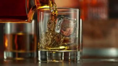 Viskiyi bardağa doldurmanın süper yavaş hareketi. High Speed Cinema Camera 'da çekildi, 1000 fps. Kamera Hareket Kontrol 'e yerleştirildi. Arkaplanda Bar, Odak Derinliği Düşük. Hız Rampası Efekti.
