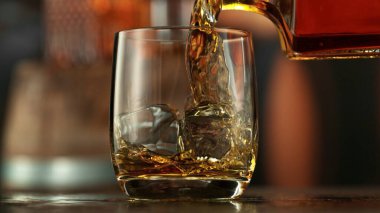İçi buz dolu bardağa viski dökmek. Hareketi dondur.