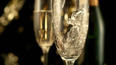 Kara Arkaplan 'a Şampanyalı Şampanyalı Şampanyaların Süper Yavaş Hareketi ve Yanıp sönen Leke Işıkları. Yüksek Hız Sineması Kamerası 'nda çekildi, 1000fps. Hız Rampası Efekti.