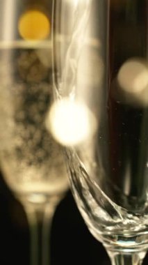 Kara Arkaplan 'a Şampanyalı Şampanyalı Şampanyaların Süper Yavaş Hareketi ve Yanıp sönen Leke Işıkları. Yüksek Hız Sineması Kamerası 'nda çekildi, 1000fps. Dikey Görünüm Oranı.