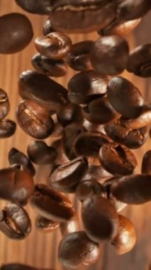 Yığının Üzerine Düşen Kahve Fasulyelerinin Süper Yavaş Hareketi. Kavrulmuş kahve çekirdeği kavramı. High Speed Cinema Camera 'da çekildi, 1000 fps. Dikey Görünüm Oranı.