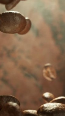 Yığının Üzerine Düşen Kahve Fasulyelerinin Süper Yavaş Hareketi. Kavrulmuş kahve çekirdeği kavramı. High Speed Cinema Camera 'da çekildi, 1000 fps. Dikey Görünüm Oranı.