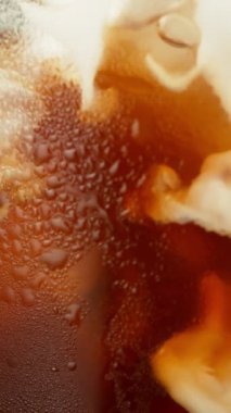 Buzlu kahve içeceğinin içine süt koymanın süper yavaş hareketi, yakın plan. High Speed Cinema Camera 'da çekildi, 1000 fps. Dikey Görünüm Oranı.