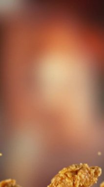 Uçan Kızarmış Tavuk Kanatları ve Parçalarının Süper Yavaş Hareketi. Arka plandaki Görüntü Özeti. Yüksek Hız Sineması Kamerası 'nda çekildi, 1000fps. Kamera hareket halinde. Dikey Görünüm Oranı.