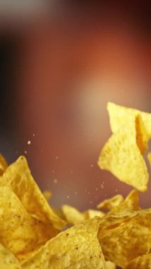 Flying Tortilla Chips 'in Süper Yavaş Hareketi. Arka plandaki Görüntü Özeti. Yüksek Hız Sineması Kamerası 'nda çekildi, 1000fps. Kamera hareket halinde. Dikey Görünüm Oranı.