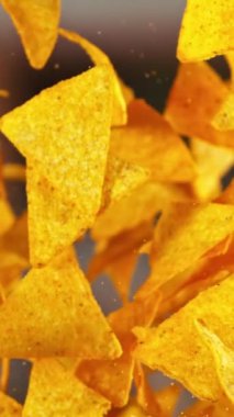 Flying Tortilla Chips 'in Süper Yavaş Hareketi. Arka plandaki Görüntü Özeti. Yüksek Hız Sineması Kamerası 'nda çekildi, 1000fps. Kamera hareket halinde. Dikey Görünüm Oranı.