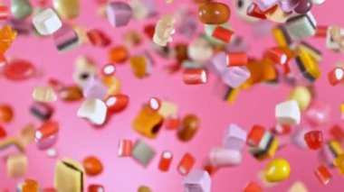 Havada Uçan Şekerlerin Süper Yavaş Hareketi. Pembe Arka plan 'da izole edilmiş. Kamera Hareket Ediyor. High Speed Cinema Camera 'da çekildi, 1000 fps. Hız Rampası Efekti.