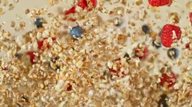 Çok Yavaş Uçan Kahvaltı Gevrekleri ve Havada Meyveler. Kahverengi Arka plan 'da izole edilmiş. Kamera Hareket Ediyor. High Speed Cinema Camera 'da çekildi, 1000 fps. Hız Rampası Efekti.