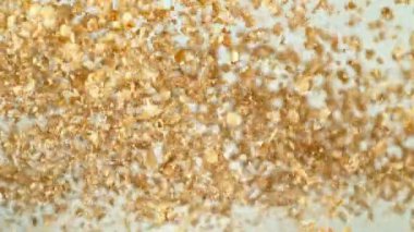 Uçan Kahvaltılık Gevreklerin Süper Yavaş Hareketi havalandı. Kahverengi Arka plan 'da izole edilmiş. Kamera Hareket Ediyor. High Speed Cinema Camera 'da çekildi, 1000 fps. Hız Rampası Efekti.