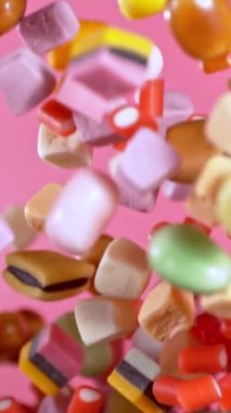 Havada Uçan Şekerlerin Süper Yavaş Hareketi. Pembe Arka plan 'da izole edilmiş. Yüksek Hız Sinema Kamerası, 1000 fp..
