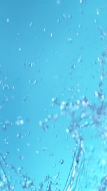 Süper Yavaş Uçan Su Sıçratma Hareketi, Mavi Arka plan 'da izole edilmiş. Yüksek Hız Sineması Kamerası 'nda çekildi, 1000fps. Dikey Görünüm Oranı.