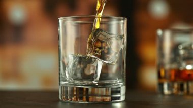 Viskiyi bardağa doldurmanın süper yavaş hareketi. High Speed Cinema Camera 'da çekildi, 1000 fps. Kamera Hareket Kontrol 'e yerleştirildi. Arkaplanda Çubuk, Odaklanma Derinliği Düşük.
