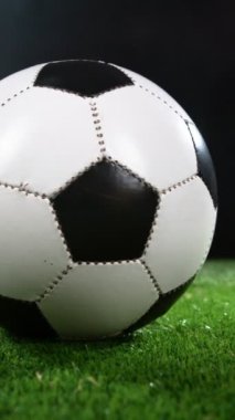 Çimenlerde dönen futbol topunun süper yavaş hareketi. Yüksek Hız Sineması Kamerası 'nda çekildi, 1000fps. Dikey Görünüm Oranı. Dikey Görünüm Oranı.