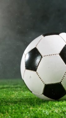 Çimenlerde Düşen Su Damlalarıyla Futbol Topu Süper Yavaş Hareketi. Yüksek Hız Sineması Kamerası 'nda çekildi, 1000fps. Dikey Görünüm Oranı.
