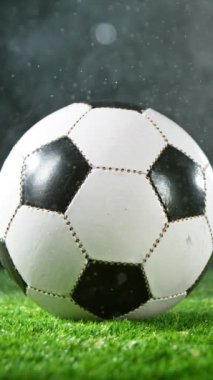 Çimenlerde Düşen Su Damlalarıyla Futbol Topu Süper Yavaş Hareketi. Yüksek Hız Sineması Kamerası 'nda çekildi, 1000fps. Dikey Görünüm Oranı.
