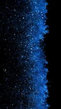 Süper Yavaş Parıldayan Mavi Parçacıklar Siyah Arkaplan 'da izole edildi. Odaklanmanın Sığ Derinliği. High Speed Cinema Camera 'da çekildi, 1000 fps. Dikey Görünüm Oranı.