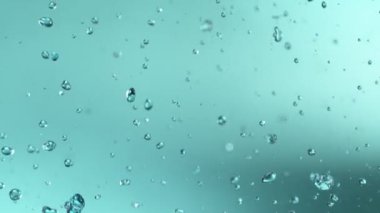 Uçan Su Damlalarının Süper Yavaş Hareketi, Mavi Arka plan 'da izole edilmiş. Yüksek Hız Sinema Kamerası, 1000fps.