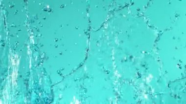 Süper Yavaş Uçan Su Sıçratma Hareketi, Mavi Arka plan 'da izole edilmiş. Yüksek Hız Sineması Kamerası 'nda çekildi, 1000fps. Hareketli Kamera.