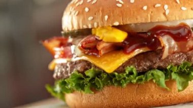 Peynirli Lezzetli Hamburger, Etrafta Kamera Dolaşıyor. Güzel Bokeh Mutfağı Arkaplanlı Taze Junk Food. Cheeseburger yemeye hazır. Hız Rampası Efekti.