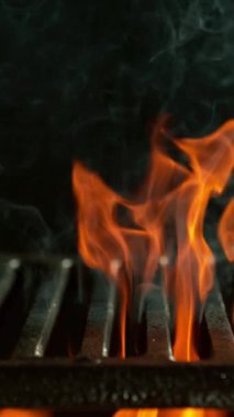 Boş ızgara ızgarası olan alevlerin çok yavaş hareket etmesi. Yüksek hızlı sinema kamerası, 1000 fps. Siyah arka planda izole edilmiş. Dikey görünüm oranı.