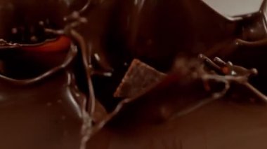 Düşen Çikolata Parçalarının Süper Yavaş Hareketi. Erimiş çikolatanın içine sıçrıyor. Yüksek Hız Sinema Kamerası, 1000fps.