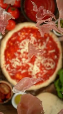 Yukarıdan Uçan Jambonla Pizza Hazırlama Konsepti. Kamera Hedefi Takip Ediyor. High Speed Cinema Camera 'da çekildi, 1000 fps. Dikey Görünüm Oranı.