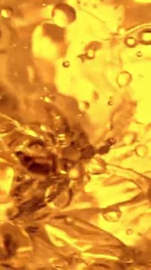 Su sıçratma yağının süper yavaş akışı. Makro soyut çekim. Yüksek hızlı sinema kamerasıyla çekildi, 1000fps. Dikey görünüm oranı.